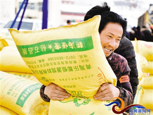 2月13日,玉树藏族自治州杂多县受灾牧民在搬运牛羊颗粒饲料.